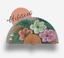 Cargar imagen en el visor de la galería, El Abanico Hibiscus enfocado hacia las mujeres que como las flores de dicho árbol son fuertes y delicadas y crecen libremente donde quiera que estén, florenciendo rodeadas de rayos de luz trayendo consigo mismas color y alegría. El abanico Hibiscus para las mujeres salvajes por naturaleza.
